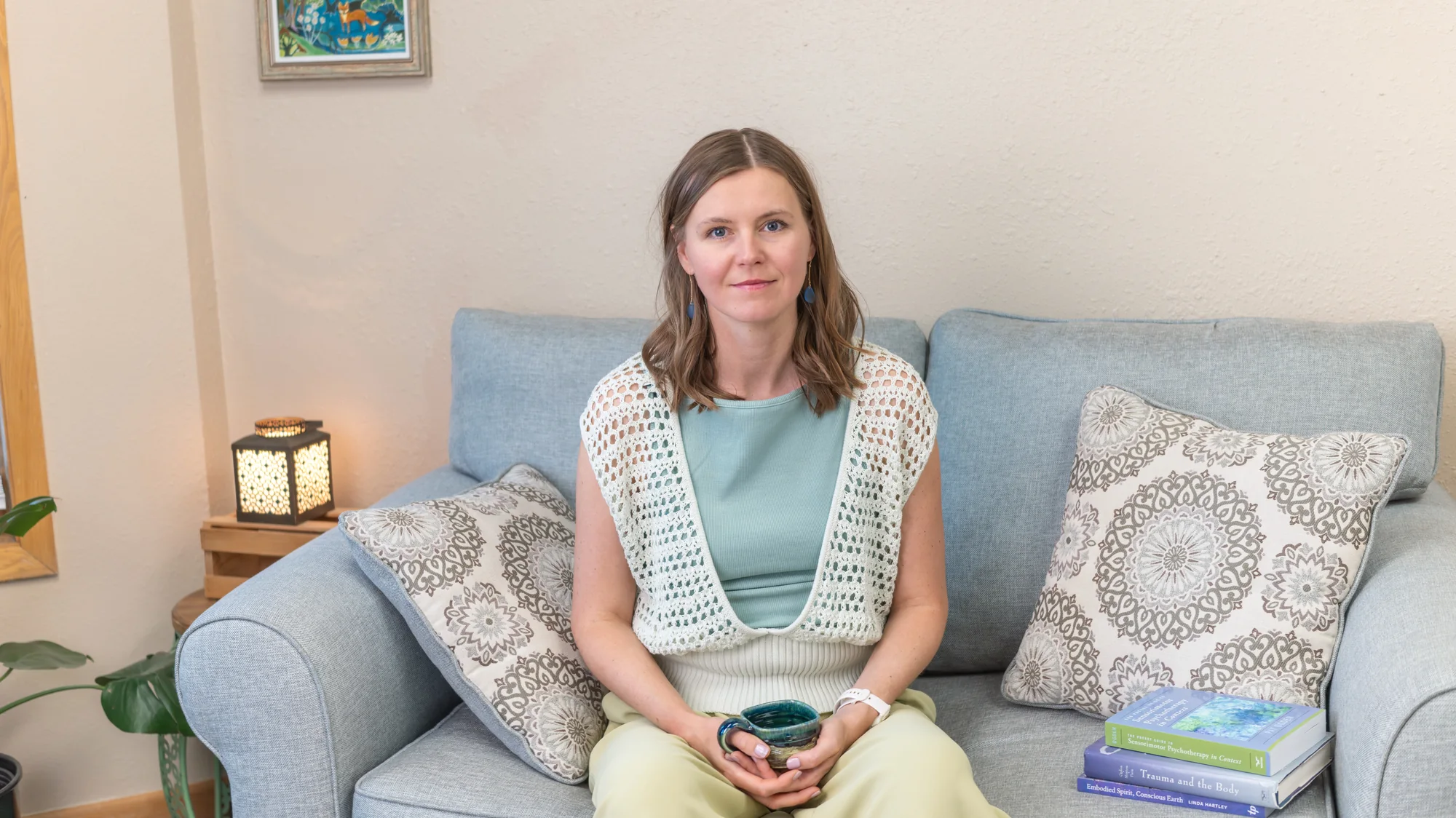 Anna seated in her Boulder therapy room, lantern lit