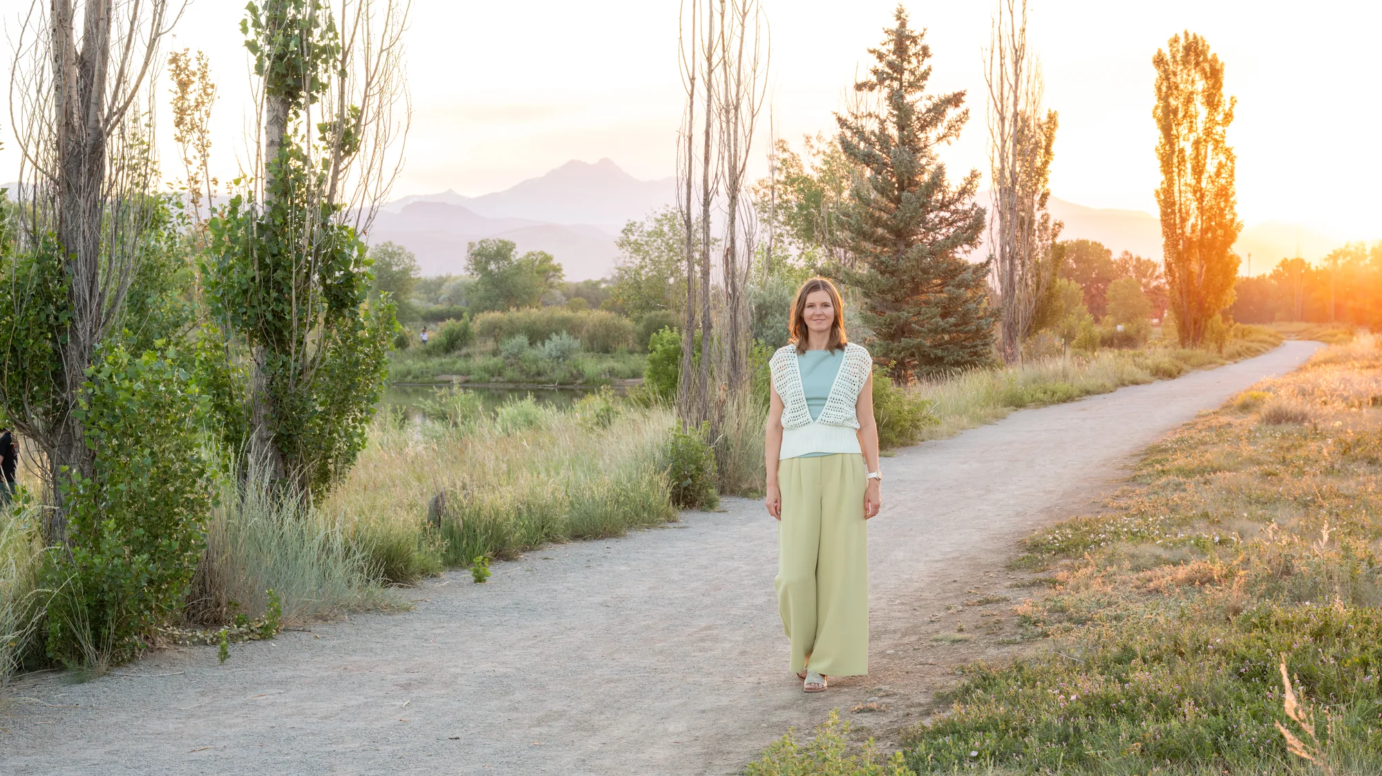 Anna walking toward the camera on a path, mountains in the distance